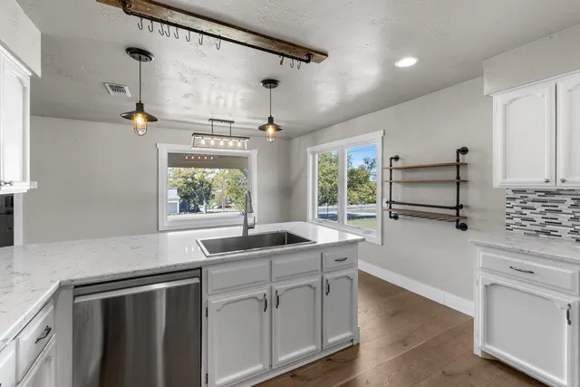 a kitchen with stainless steel appliances a sink stove and window