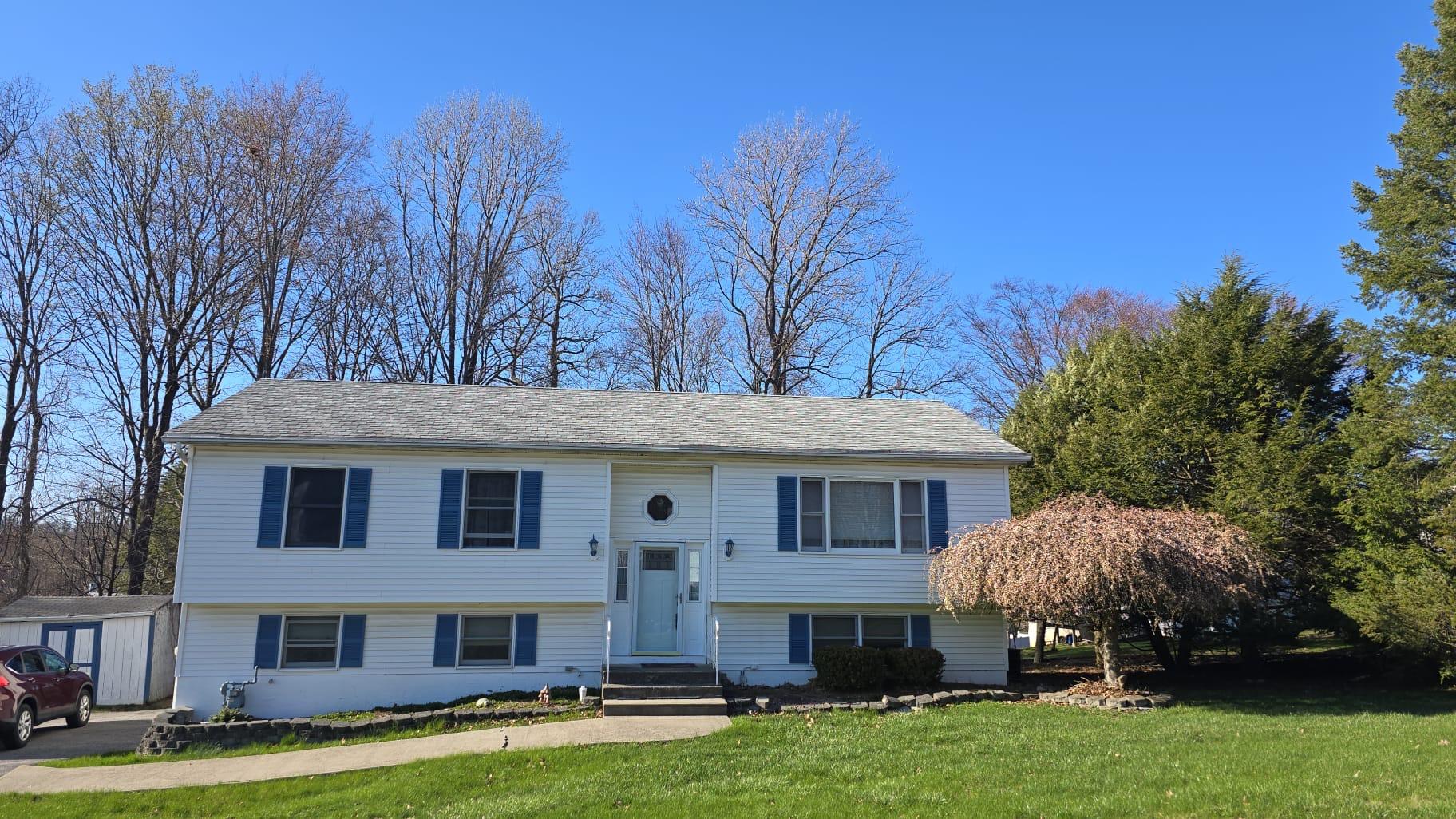 a front view of a house with a garden and plants