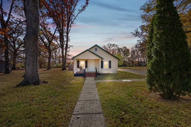 a view of house with backyard and trees