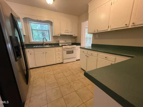 a kitchen with a stove window and cabinets