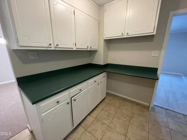 a kitchen with granite countertop white cabinets and a sink
