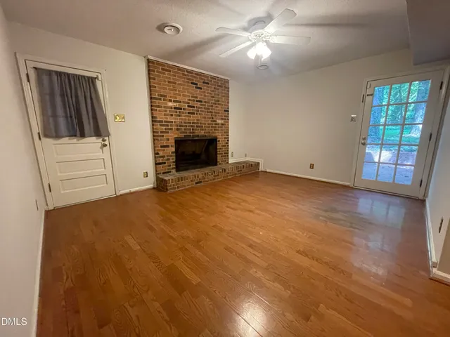 an empty room with windows and fireplace