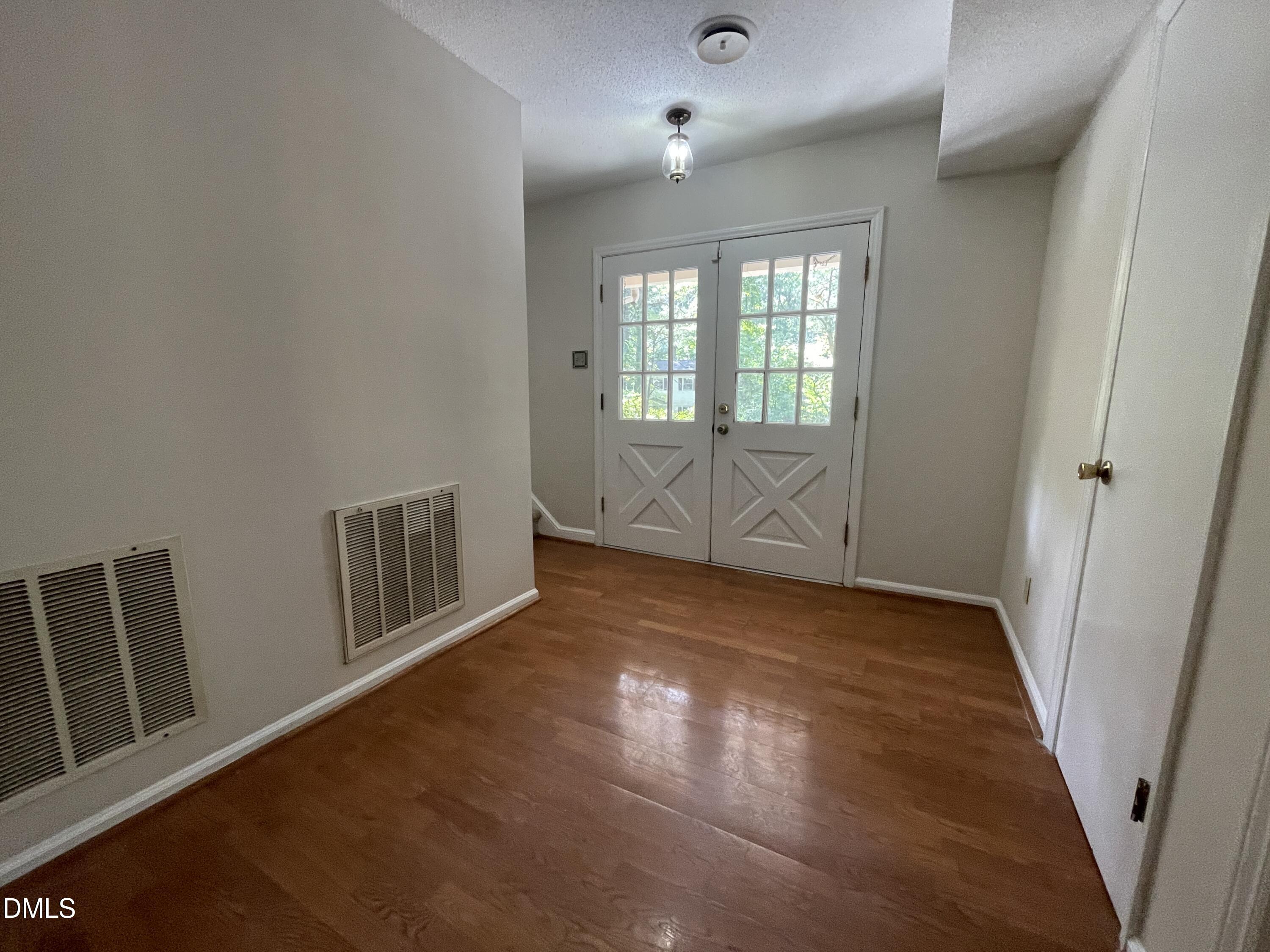 314 Brandywine Road Chapel Hill, NC 27516 - Photo 6 of 17 an empty room with wooden floor and windows