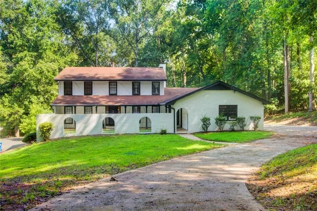 a view of a house with a yard and sitting area