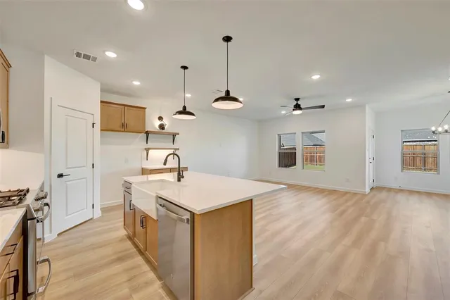 a kitchen with kitchen island a sink stainless steel appliances and cabinets