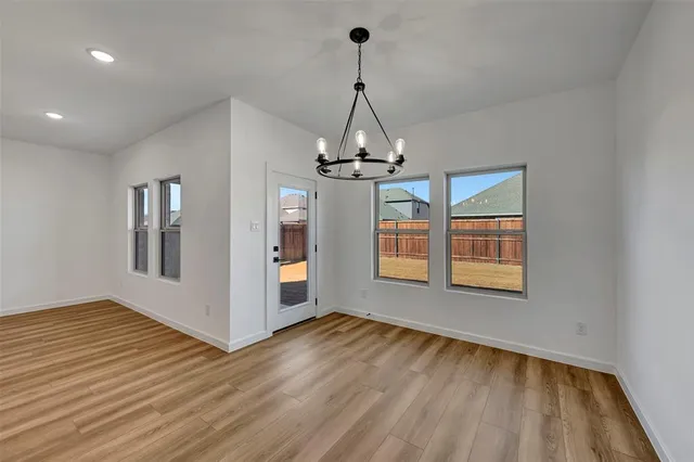 a view of a room with wooden floor chandelier and windows