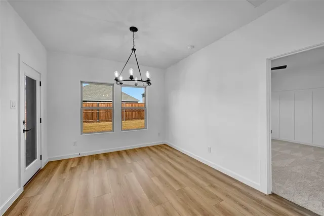 a view of a room with wooden floor staircase and a chandelier
