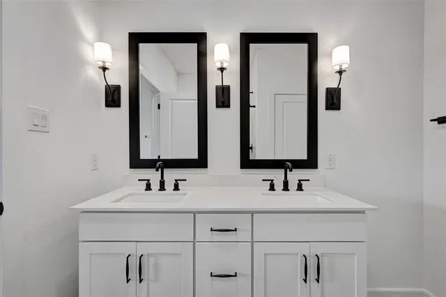 a bathroom with double vanity sinks and a mirror