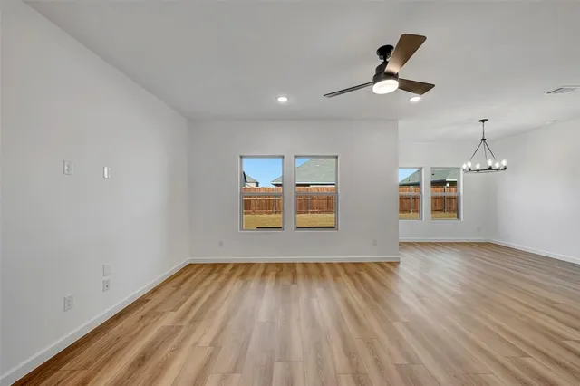 a view of empty room with wooden floor and window