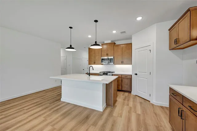 a kitchen with a sink wooden floor and white cabinets