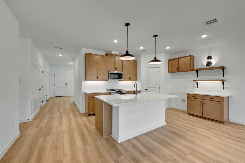 524 Brookside Drive Van Alstyne, TX 75495 - Photo 10 of 32 a large kitchen with stainless steel appliances kitchen island granite countertop a stove a sink and a granite counter top