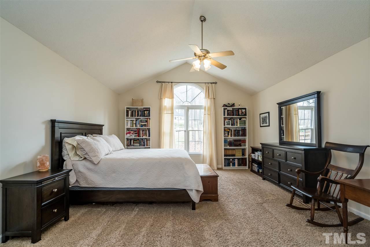 1000 Highlander Drive Raleigh, NC 27603 - Photo 14 of 28 a spacious bedroom with a bed a dresser and a chandelier