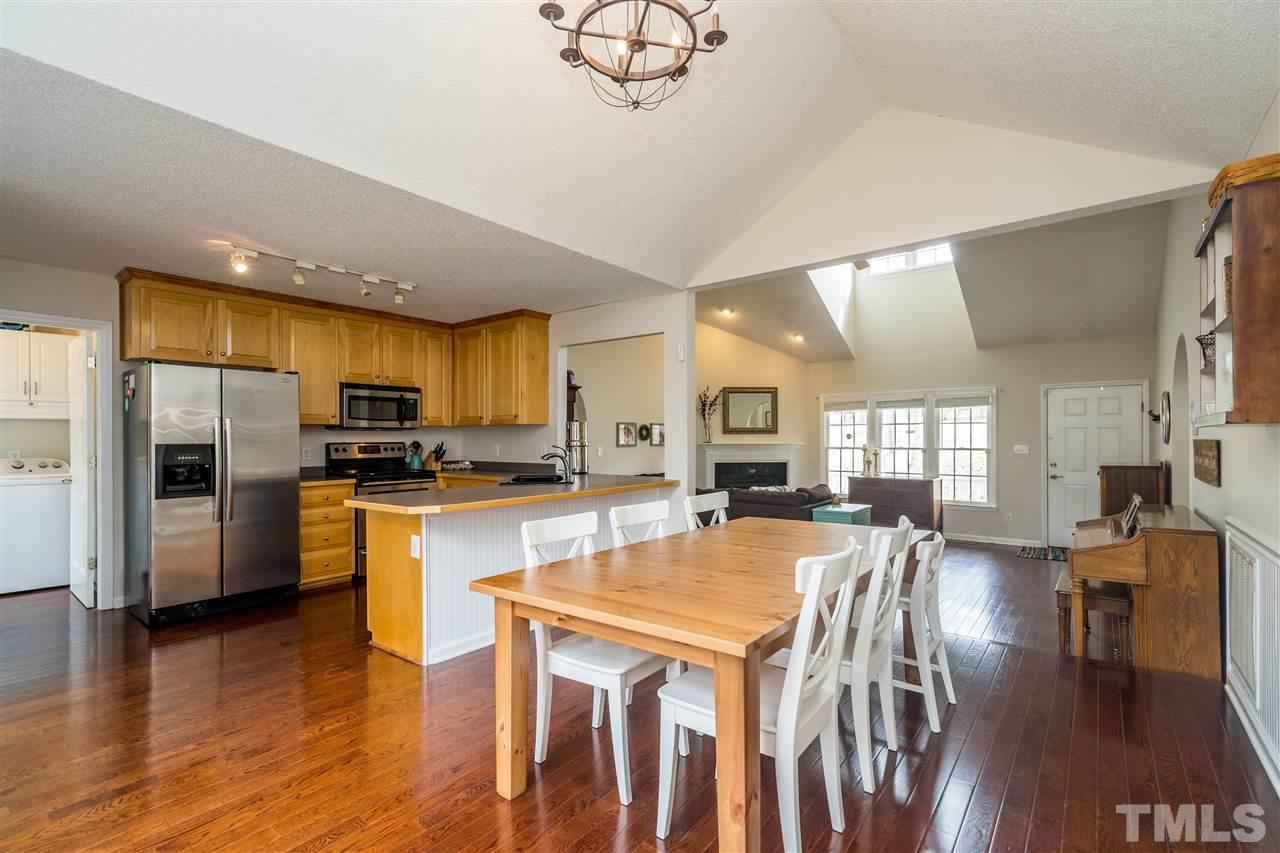 1000 Highlander Drive Raleigh, NC 27603 - Photo 8 of 28 a kitchen with stainless steel appliances granite countertop a refrigerator a stove top oven a sink dishwasher a dining table and chairs with wooden floor