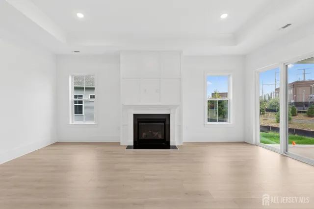 a view of an empty room with a fireplace and a window