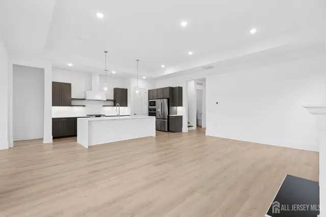 a view of kitchen with kitchen island a sink stainless steel appliances and cabinets
