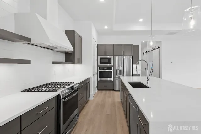 a kitchen with kitchen island stainless steel appliances a sink stove and refrigerator