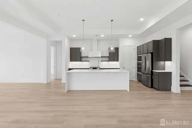 a large kitchen with stainless steel appliances kitchen island granite countertop a stove a refrigerator a sink and a oven