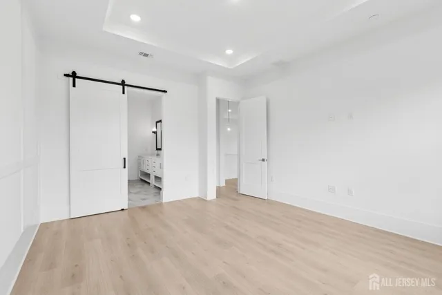a view of a big room with wooden floor and bathroom view