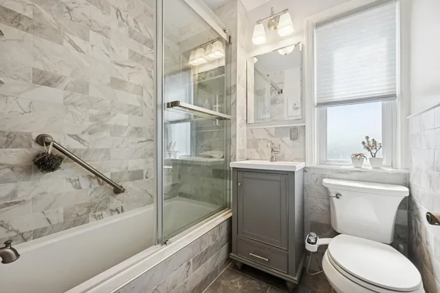 a bathroom with a granite countertop toilet a sink and a bathtub