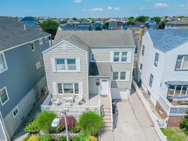an aerial view of a house with a yard potted plants and large tree