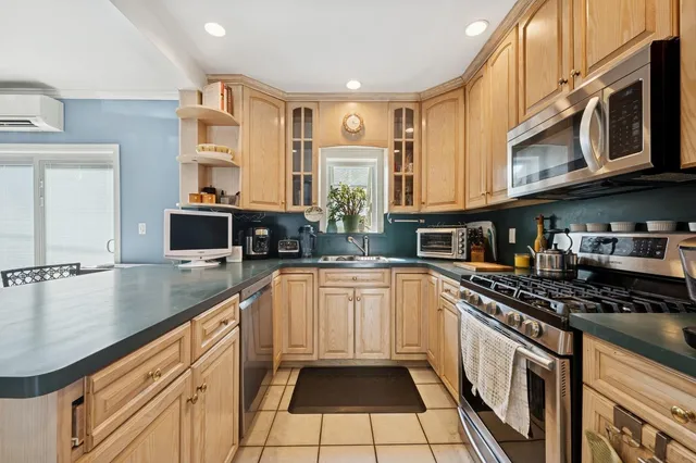 a kitchen with stainless steel appliances granite countertop a stove a sink and a microwave