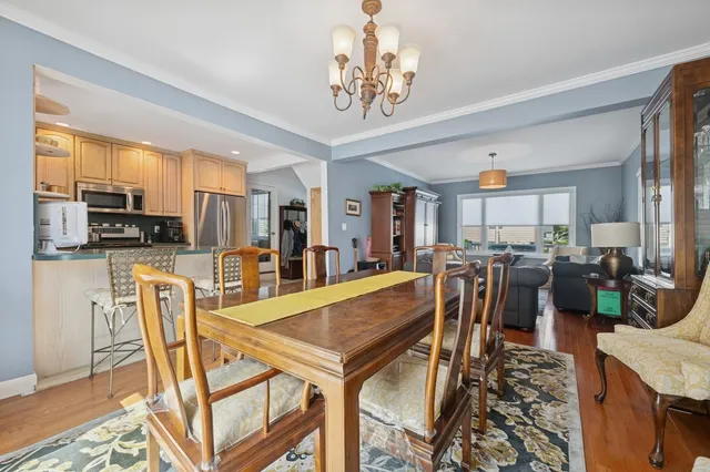 a view of a dining room with furniture a kitchen and chandelier
