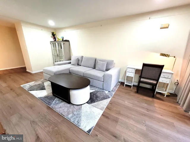 a living room with furniture a flat screen tv and a table