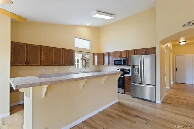 a kitchen with stainless steel appliances granite countertop a refrigerator a stove and a sink