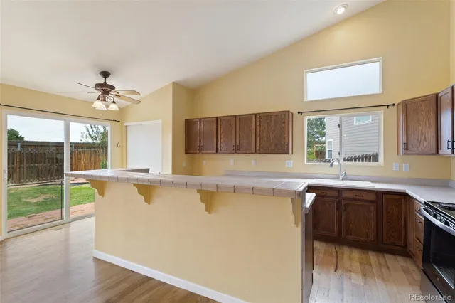 a large kitchen with a sink and large windows