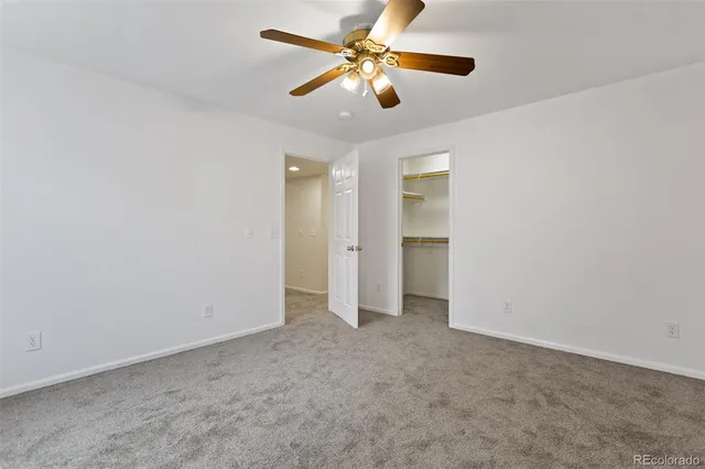 an empty room with fan and windows