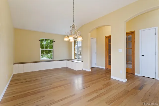 a view of a big room with wooden floor and windows
