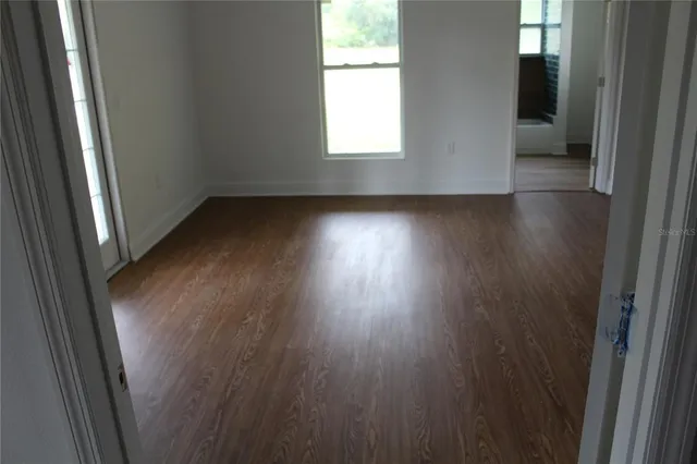 a view of empty room with wooden floor