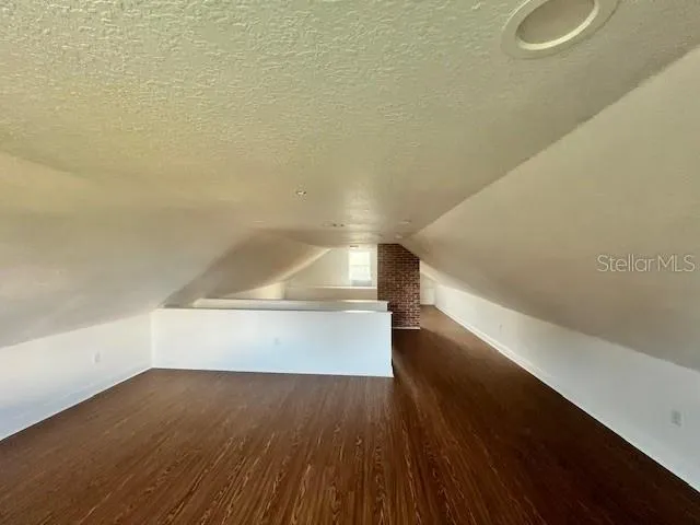 an empty room with wooden floor and mirror