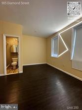 905 Diamond Street, Unit 200 Philadelphia, PA 19122 - Photo 7 of 8 a view of an empty room with wooden floor and a window