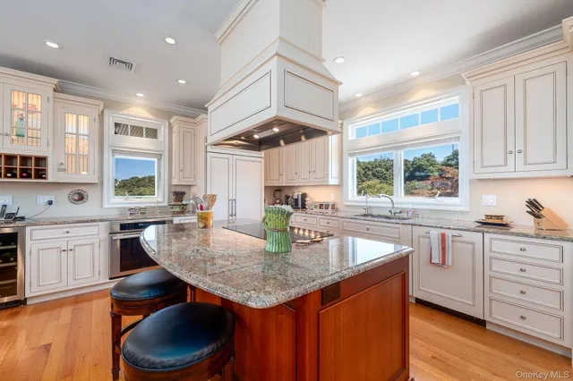 a kitchen with stainless steel appliances granite countertop a stove a sink dishwasher and cabinets with wooden floor
