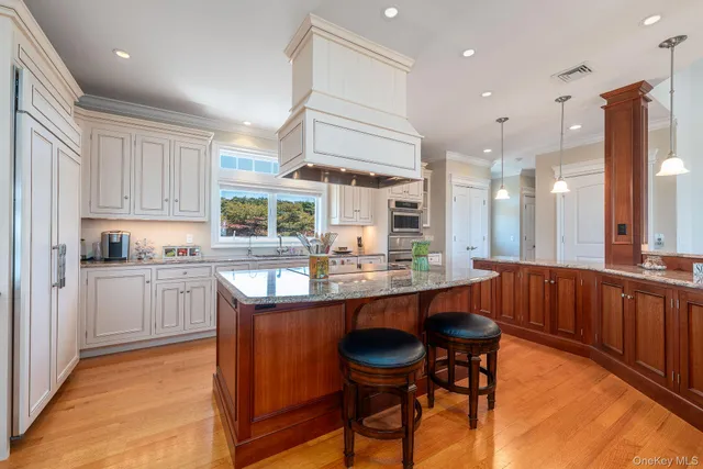 a kitchen with stainless steel appliances granite countertop wooden cabinets a dining table and chairs