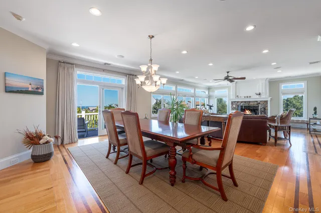a view of a dining room and livingroom with furniture wooden floor a chandelier