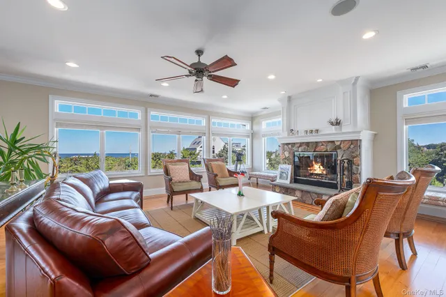 a living room with furniture a fireplace and a dining table with wooden floor