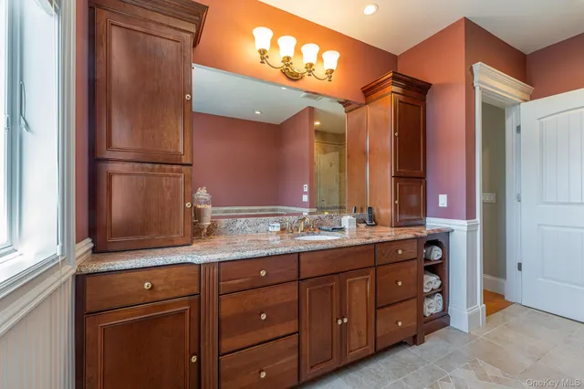 a bathroom with a granite countertop sink double vanity and a mirror