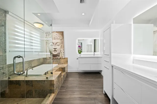 a bathroom with a tub sink and mirror