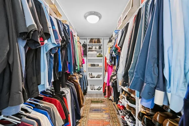 a view of walk in closet with clothes