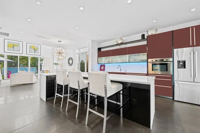 a kitchen with stainless steel appliances a table chairs refrigerator and microwave