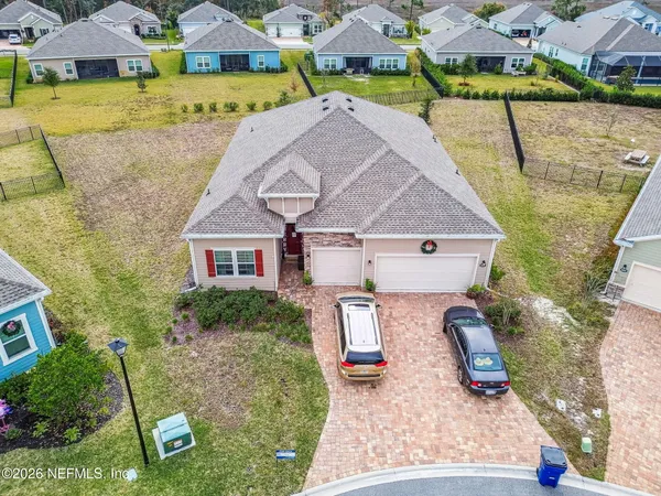 an aerial view of a house with garden space and a car park in front of it