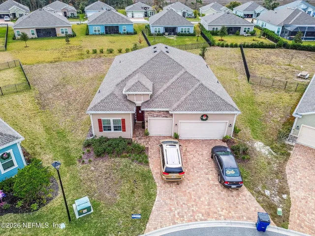an aerial view of a house with garden space and a car park in front of it