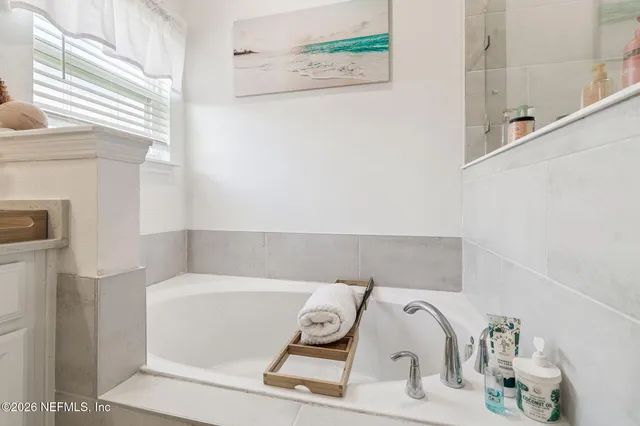 a kitchen with stainless steel appliances kitchen island granite countertop a refrigerator oven a sink dishwasher and white cabinets with wooden floor