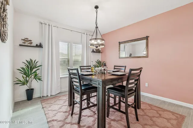 a view of a dining room with furniture a chandelier and wooden floor