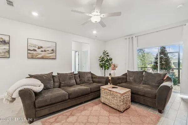 a living room with furniture a flat screen tv and kitchen view