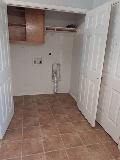 1309 Marlee Circle Copperas Cove, TX 76522 - Photo 14 of 16 Laundry area featuring cabinet space, hookup for a washing machine, electric dryer hookup, and light tile patterned floors