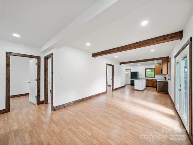 a view of a big room with wooden floor and a kitchen
