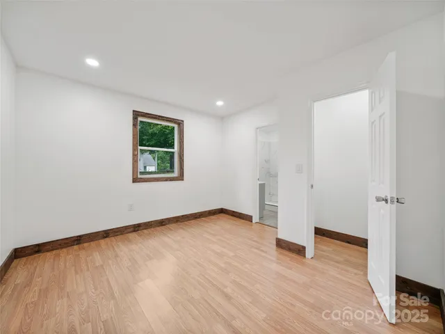 an empty room with wooden floor and a window